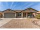 Charming single-story home featuring a low-maintenance desert landscape, covered porch, and two-car garage at 43554 W Sunland Dr, Maricopa, AZ 85138