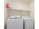 Functional laundry room featuring modern washer and dryer with shelf storage at 43554 W Sunland Dr, Maricopa, AZ 85138