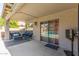 Covered patio features a seating area and view through sliding glass doors to backyard swimming pool at 43554 W Sunland Dr, Maricopa, AZ 85138