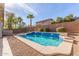 Backyard swimming pool with rock surround, waterfall features, and a clear blue sky overhead at 43554 W Sunland Dr, Maricopa, AZ 85138