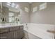 Bathroom featuring a soaking tub, modern lighting, and spacious vanity with ample counter space at 4498 E Bethena St, Gilbert, AZ 85295