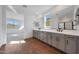 Bathroom with gray cabinets, double sinks, tile floors, and view to bedroom and shower at 4552 W Willow Run --, San Tan Valley, AZ 85144