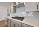 Modern kitchen featuring stainless steel stove and hood, tile backsplash and gray cabinetry at 4552 W Willow Run --, San Tan Valley, AZ 85144