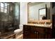 Bathroom with a glass-enclosed shower, granite counters, and dark wood cabinetry, providing a spa-like experience at 5016 E Butler Dr, Paradise Valley, AZ 85253