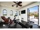 Home gym with a ceiling fan, exercise equipment, and French doors leading to a balcony with a mountain view at 5016 E Butler Dr, Paradise Valley, AZ 85253