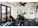 Home gym with exercise equipment, multiple windows, and French doors leading to a balcony with a view of the mountains at 5016 E Butler Dr, Paradise Valley, AZ 85253