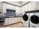 Well-appointed laundry room with modern appliances, custom cabinetry, and beautiful blue tile backsplash at 5016 E Butler Dr, Paradise Valley, AZ 85253