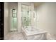 Bright bathroom featuring a glass shower, chandelier, and luxurious soaking tub at 5016 E Butler Dr, Paradise Valley, AZ 85253