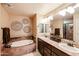 The primary bathroom boasts a large soaking tub and dual sink vanity with warm lighting and decor at 5350 E Deer Valley Dr # 3277, Phoenix, AZ 85054