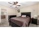 Cozy bedroom with ceiling fan, window, bedside table, and dark wood furnishings at 5401 N 81St Pl, Scottsdale, AZ 85250