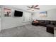 Bright living room with gray carpet, large window with white shutters, and a comfortable leather couch at 5401 N 81St Pl, Scottsdale, AZ 85250