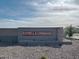 Estrella Crossing community sign with neutral block wall and desert landscaping under blue skies at 5515 W Hopi Trl, Laveen, AZ 85339