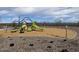 Community playground featuring swings, slides, and climbing structures on wood chip ground cover at 5515 W Hopi Trl, Laveen, AZ 85339