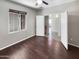 A bedroom with a ceiling fan and dark floors, showcasing natural light through a large window at 5822 W Huntington Dr, Laveen, AZ 85339