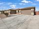 Exterior shot of home featuring an attached garage, stone accents, and desert landscaping at 5822 W Huntington Dr, Laveen, AZ 85339