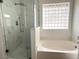 Walk-in shower with glass door and a separate soaking tub with tub window at 60 W Shamrock St, Gilbert, AZ 85233