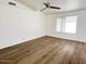 Bright bedroom featuring modern ceiling fan and light, with sleek wood-look flooring and a vaulted ceiling at 60 W Shamrock St, Gilbert, AZ 85233