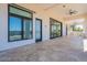 Expansive covered patio with travertine tile, ceiling fans, and large sliding doors for indoor/outdoor living at 6378 S 154Th St, Gilbert, AZ 85298