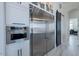 Kitchen area featuring stainless steel refrigerator and built-in oven with white cabinets at 6378 S 154Th St, Gilbert, AZ 85298