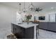 Open kitchen island with sink and barstool seating, next to the living room at 6378 S 154Th St, Gilbert, AZ 85298