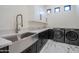 A modern laundry room featuring stainless steel sink, quartz counters, and front loading washer/dryer at 6378 S 154Th St, Gilbert, AZ 85298