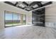 Open living room with tiled floors, a black coffered ceiling, built-in shelving, and sliding glass doors at 6378 S 154Th St, Gilbert, AZ 85298