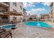 Community pool area with in-ground pool and hot tub, as well as multiple lounge chairs and umbrellas at 7609 E Indian Bend Rd # 2008, Scottsdale, AZ 85250