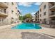 Outdoor swimming pool surrounded by residential buildings, patio furniture and desert landscaping at 7609 E Indian Bend Rd # 2008, Scottsdale, AZ 85250