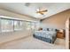 Sunlit main bedroom with a ceiling fan, carpeted floors, and multiple windows at 7712 N 54Th Ln, Glendale, AZ 85301