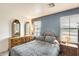 Cozy bedroom with a wooden dresser, bedside table, and natural light from windows at 7712 N 54Th Ln, Glendale, AZ 85301