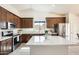 Modern kitchen with stainless steel appliances, quartz countertops, and dark wood cabinets at 7712 N 54Th Ln, Glendale, AZ 85301