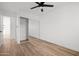 Bedroom with a large mirrored closet, ceiling fan, and wood-look flooring for a contemporary look at 8525 E Clarendon Ave, Scottsdale, AZ 85251