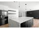 Stylish kitchen featuring a waterfall island, stainless steel appliances, open shelving, and white cabinets at 8525 E Clarendon Ave, Scottsdale, AZ 85251