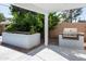 An outdoor kitchen features a built-in grill, complemented by lush landscaping for private, outdoor dining at 8525 E Clarendon Ave, Scottsdale, AZ 85251