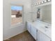 Bright bathroom featuring double sinks, white cabinetry, and a large mirror at 8722 W Wilshire Dr, Phoenix, AZ 85037