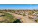 Neighborhood aerial view featuring mature trees, a golf course, and mountain views in the distance at 902 S Saranac Ave, Mesa, AZ 85208