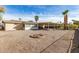 Large backyard with gravel, a fire pit, palm trees and a covered patio at 902 S Saranac Ave, Mesa, AZ 85208