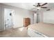 Neutral carpeted bedroom with ceiling fan, closet, and attached renovated bathroom at 902 S Saranac Ave, Mesa, AZ 85208