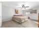 Bedroom with carpet, fan, and a comfortable king-sized bed with neutral bedding at 902 S Saranac Ave, Mesa, AZ 85208