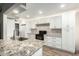 Modern kitchen featuring granite countertops, white cabinetry, and black appliances at 902 S Saranac Ave, Mesa, AZ 85208