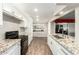 Kitchen with granite countertops, white cabinets, black appliances and wood floors at 902 S Saranac Ave, Mesa, AZ 85208