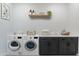 Well-equipped laundry room with modern washer and dryer, cabinetry, and ample counter space at 11242 E Crescent Ave, Mesa, AZ 85208