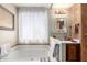 Bathroom with a large bathtub, a window, a mirror, and a vanity at 11411 N 91St Ave # 48, Peoria, AZ 85345