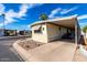 Charming mobile home with a covered carport, set in a peaceful community with ample parking space and desert landscaping at 11411 N 91St Ave # 48, Peoria, AZ 85345