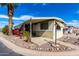 Well-maintained mobile home featuring desert landscaping with a quaint covered patio, perfect for outdoor living at 11411 N 91St Ave # 48, Peoria, AZ 85345