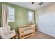 bedroom featuring a crib, chair, and white closet doors at 1255 N Arizona Ave # 1093, Chandler, AZ 85225