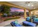 Spacious covered patio with seating and view of landscaped backyard at 12663 W Pinnacle Vista Dr, Peoria, AZ 85383
