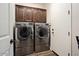 Laundry room with front load washer and dryer and overhead storage at 12663 W Pinnacle Vista Dr, Peoria, AZ 85383