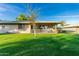 This home features a generous backyard with a verdant lawn and covered patio, perfect for outdoor living at 12703 W Shadow Hills Dr, Sun City West, AZ 85375