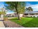 Nice home with a large tree in the front, grassy yard, and a driveway leading to the garage at 12703 W Shadow Hills Dr, Sun City West, AZ 85375